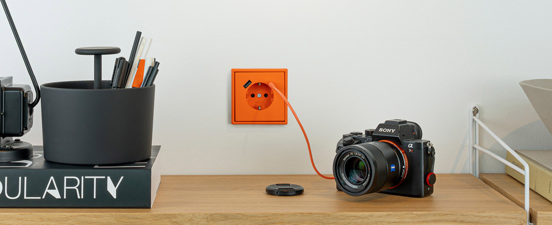 Kamera lädt über USB Anschluss in orange von Jung