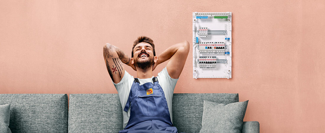 Flexline von ABB - Bequeme Installatiion Bild eines Handwerker auf der Couch im Hintergrund Schaltschrank von ABB Flexline