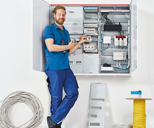 Bild eines Mannes vor einem Sicherungskasten bestückt mit ABB Produkten