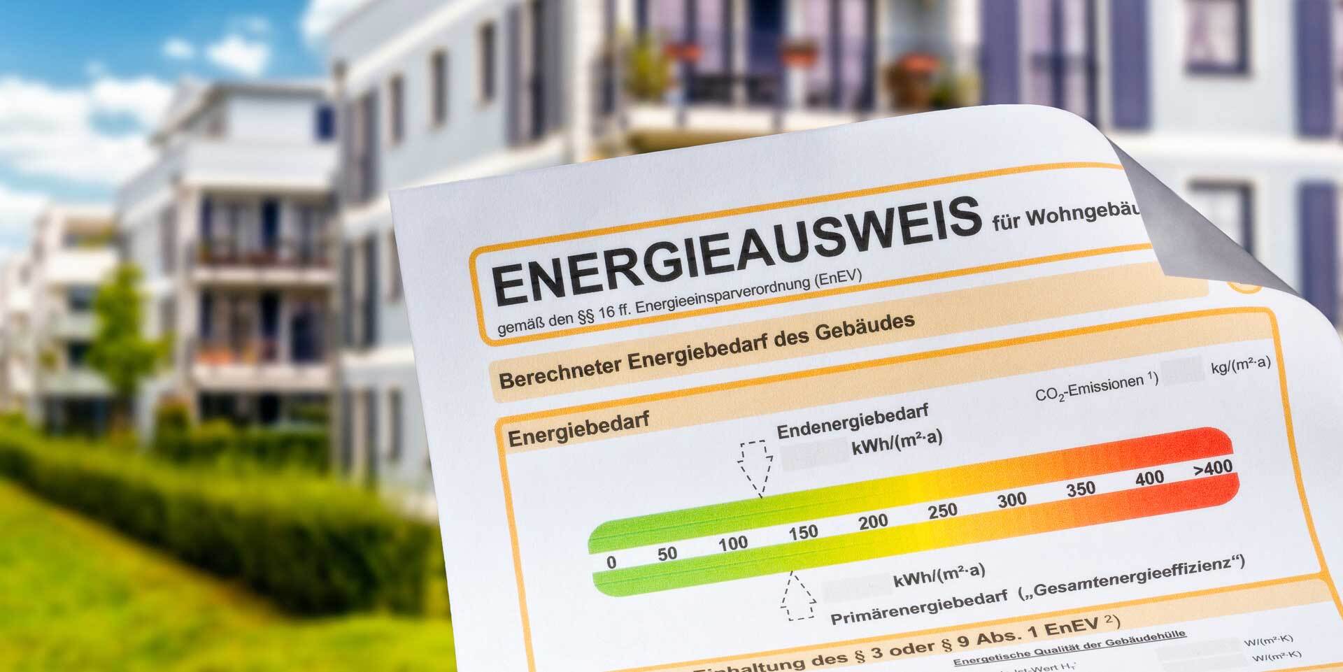 Gebäude im Hintergrund und ein Energieausweis im Vordergrund