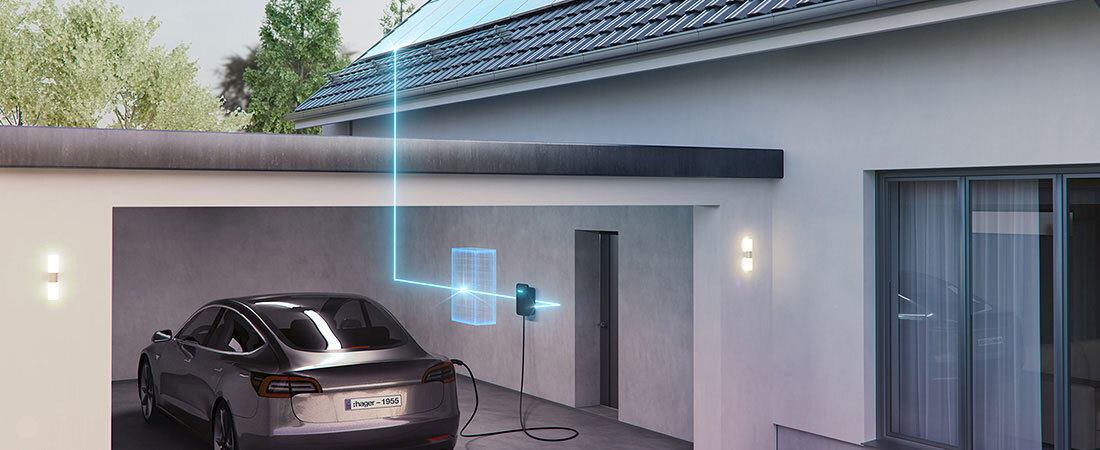 Bild eines E-Autos im Carport, welches an der Ladestation witty von Hager lädt.