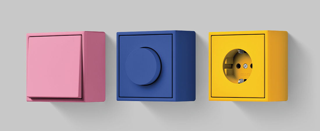 pink, blau und gelbe Ausführung der LS Aufputzsteckdosen von JUNG